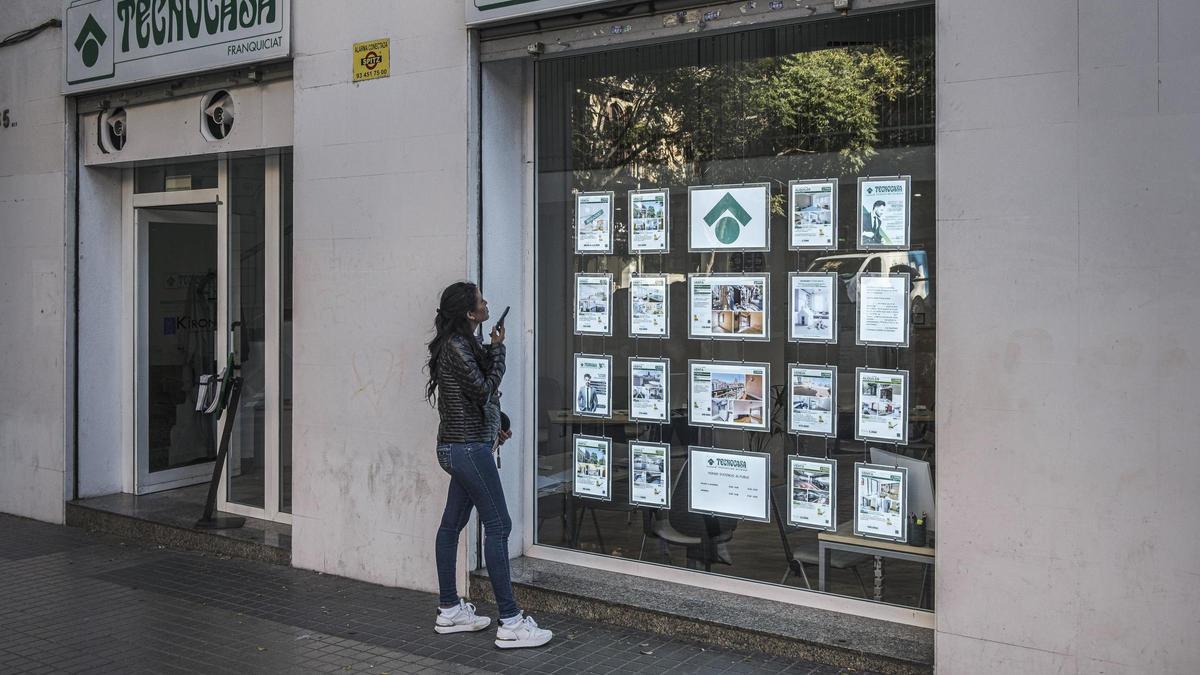 Una noia mirant anuncis de pisos en una immobiliària.