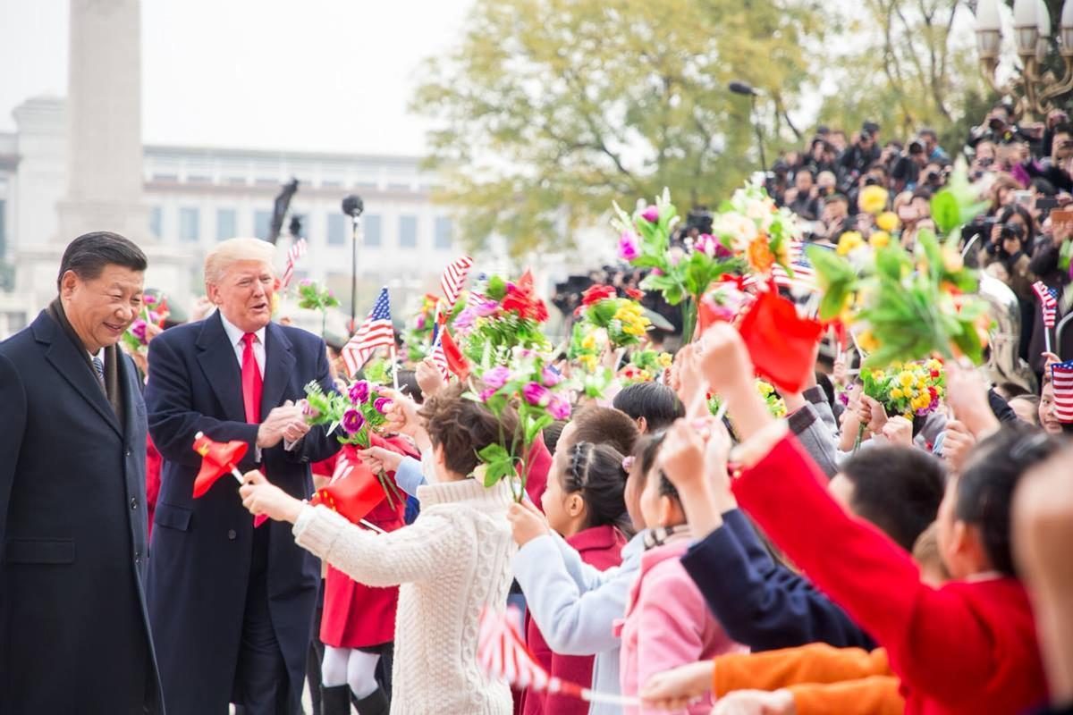 El presidente de EEUU, Donald Trump, y el presidente chino, Xi Jinping, son recibidos por niños que ondean banderas durante la ceremonia formal de llegada el 9 de noviembre de 2017, en Beijing, China.