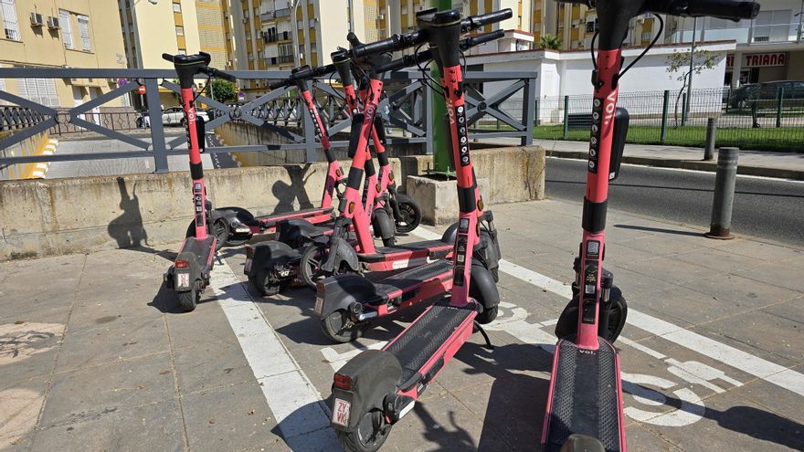 Patinetes de Voi estacionados en una calle de Triana a mediados de julio.
