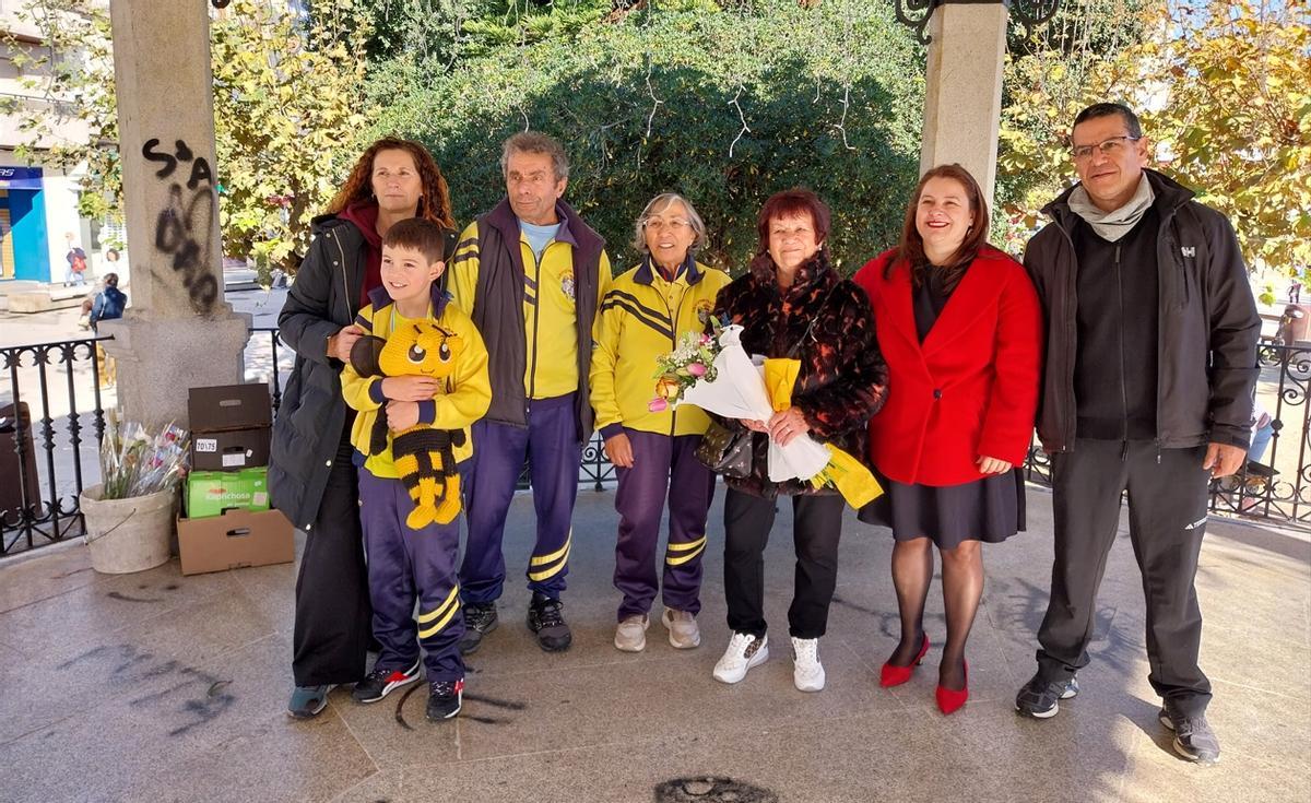 Representantes del Concello de Cangas y del Atletismo Vila de Cangas brindan a la viuda de Pepe Cordero, Carmiña Pérez (en el centro con un ramo de flores), un homenaje al final de la carrera.