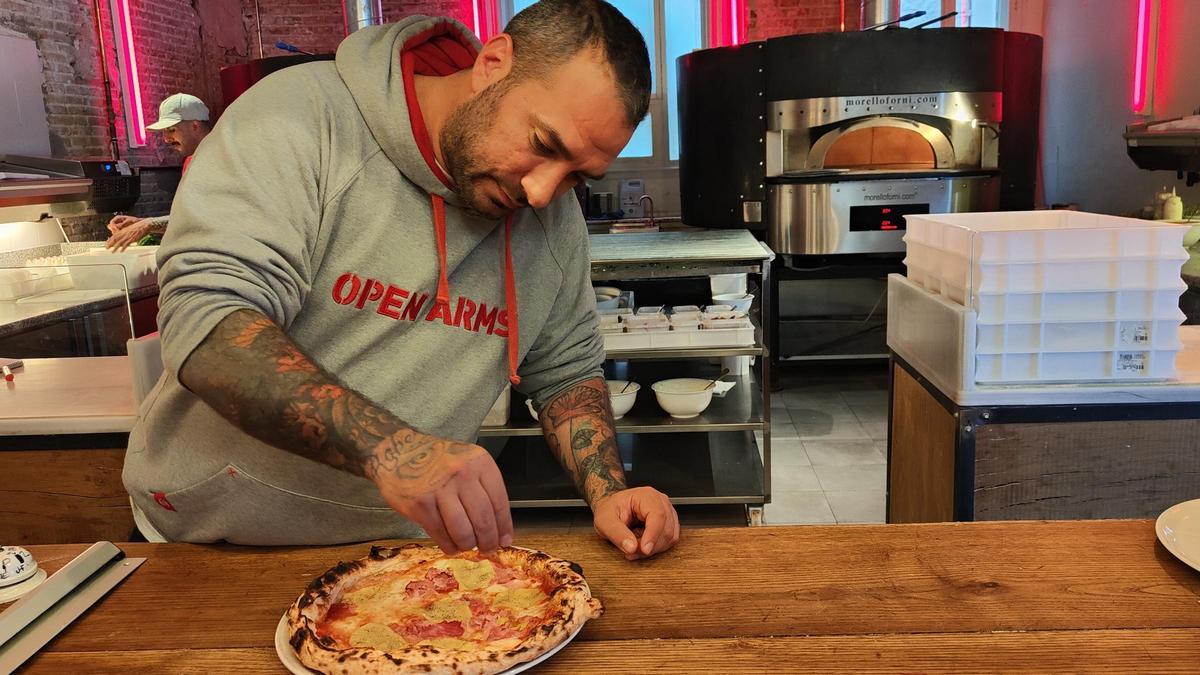 Lollo Vuoturni añade pimienta a la pizza con piña de Can Pizza.