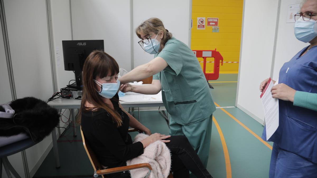 Una ciudadana recibe una dosis de la vacuna contra el coronavirus en el Polideportivo Germans Escalas