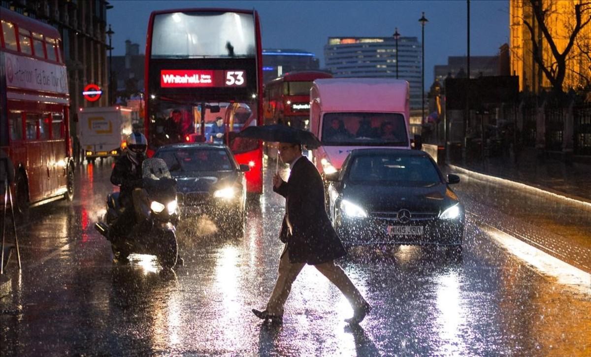 jjubierre36852458 a pedestrian walks in heavy rain near the houses of parliame170113104102