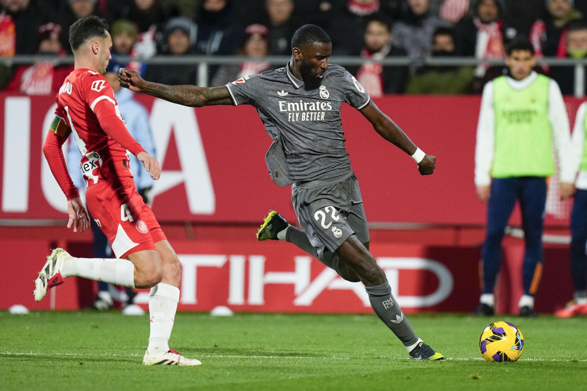 GIRONA, 07/12/2024.- El defensa del del Real Madrid Antonio Rudiger (d) centra el balón durante el partido de la jornada 19 de LaLiga que Girona FC y Real Madrid disputan este sábado en el estadio Montilivi, en Girona. EFE/Siu Wu