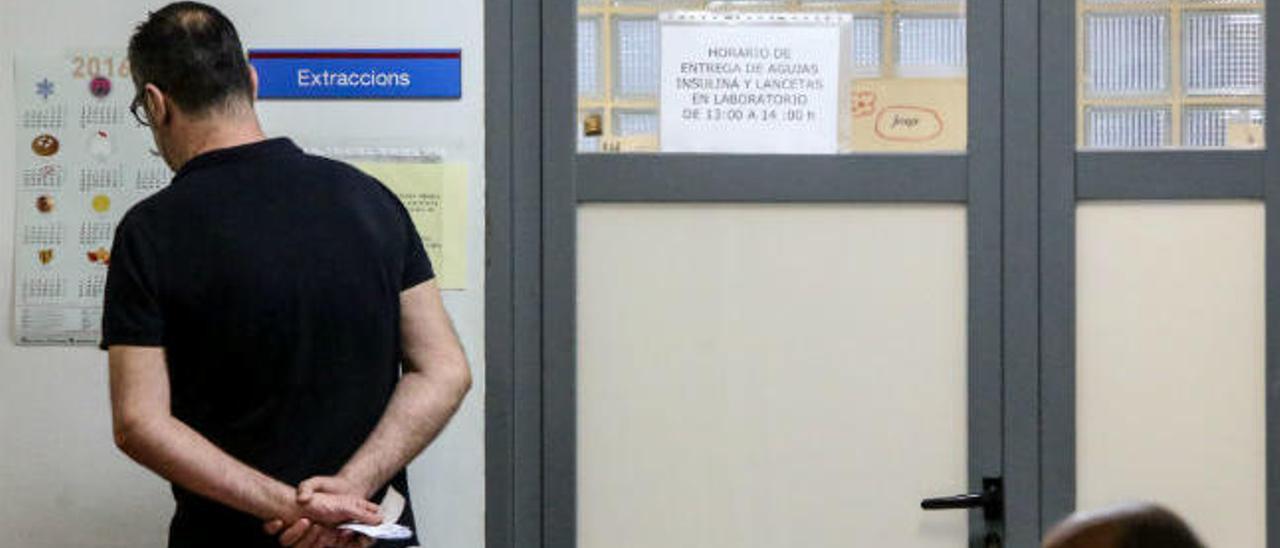 Un usuario lee un cartel junto a la sala de Extracciones del ambulatorio de Tomás Ortuño, en Benidorm