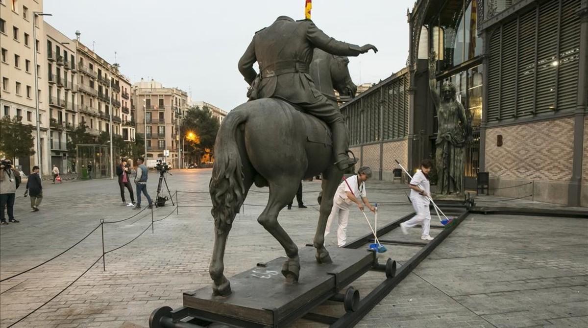 Los servicios de limpieza trabajan junto a la estatua de Franco en el Born, que luego sería derribada.