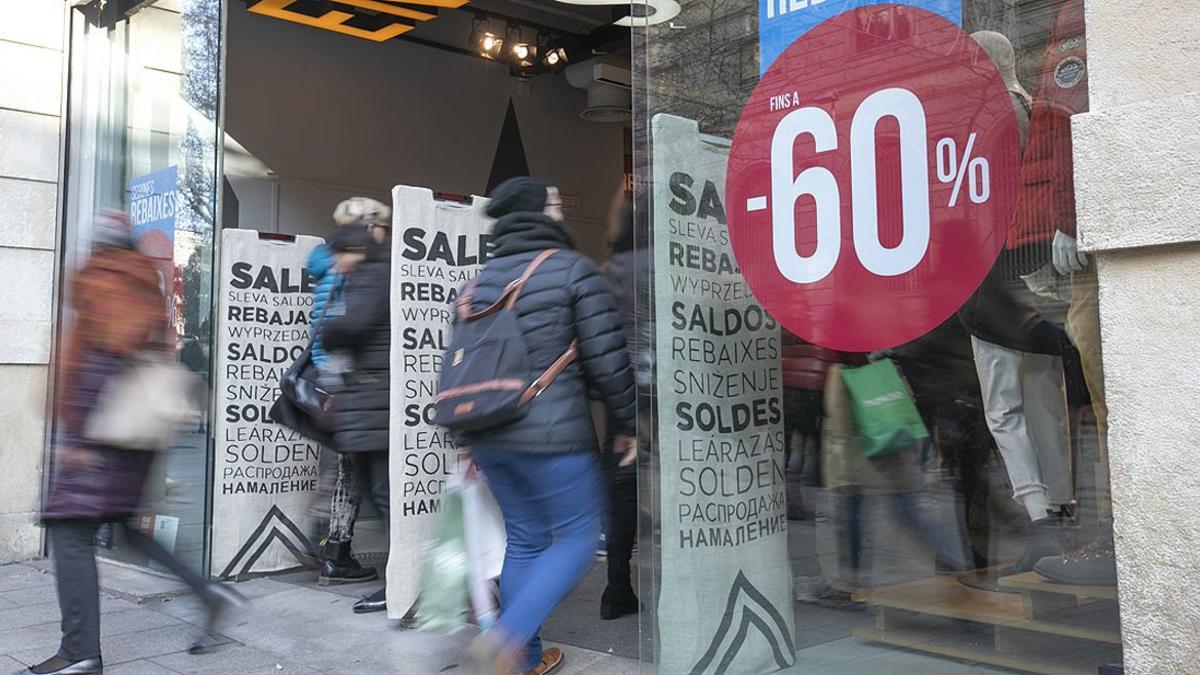 Carteles de rebajas en una tienda de moda del Portal de l'Àngel de Barcelona, este sábado