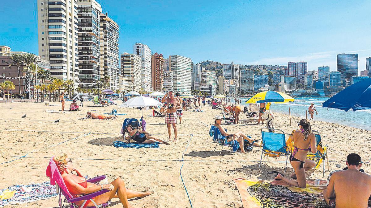 Turistas disfrutando de la playa de Levante de Benidorm este otoño.