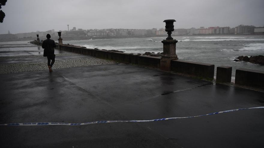 Paseantes, vecinos posando y hasta un niño entre las olas de la rotonda de As Esclavas, en A Coruña