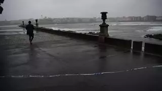 Paseantes, vecinos posando y hasta un niño entre las olas de la rotonda de As Esclavas, en A Coruña