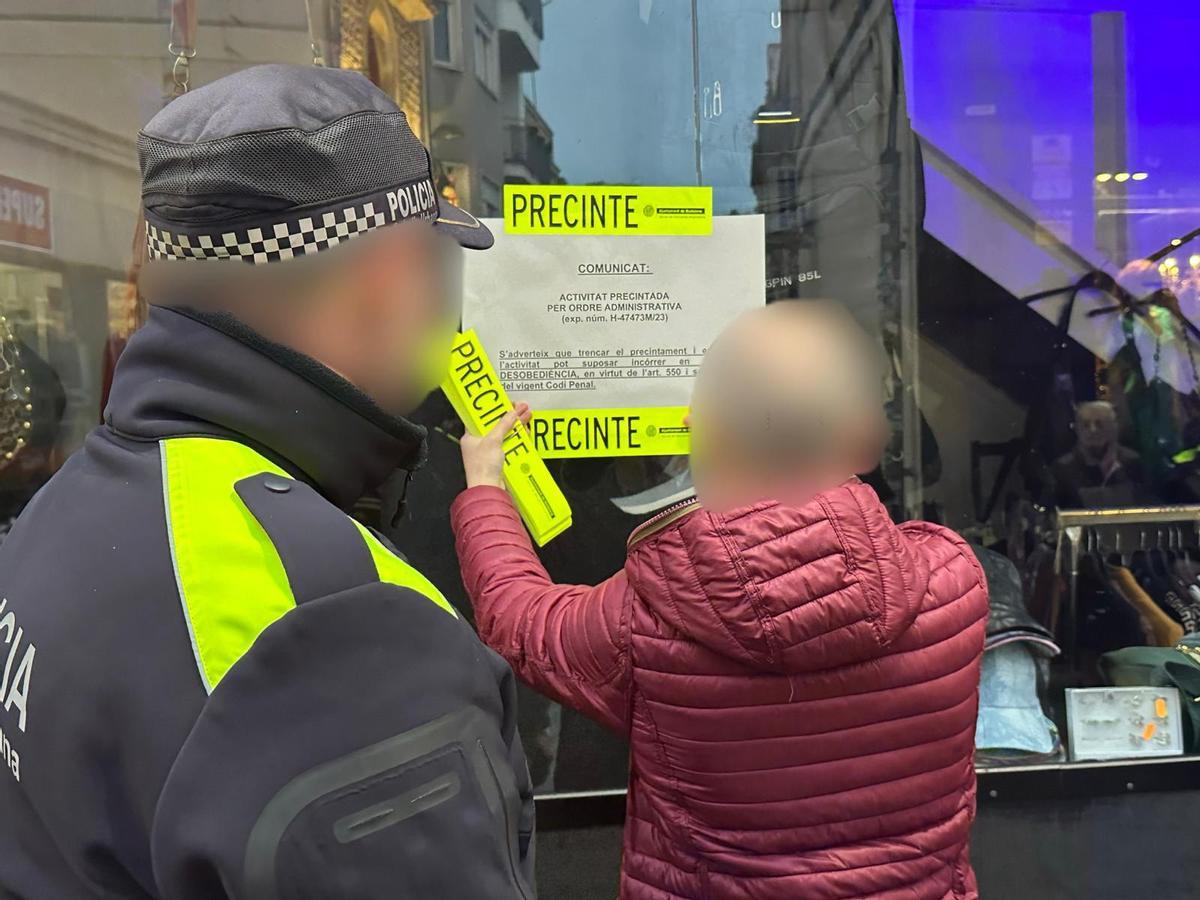 Operarios municipales precintan una tienda de la calle del Mar de Badalona que operaba sin licencia y en pésimas condiciones de salubridad