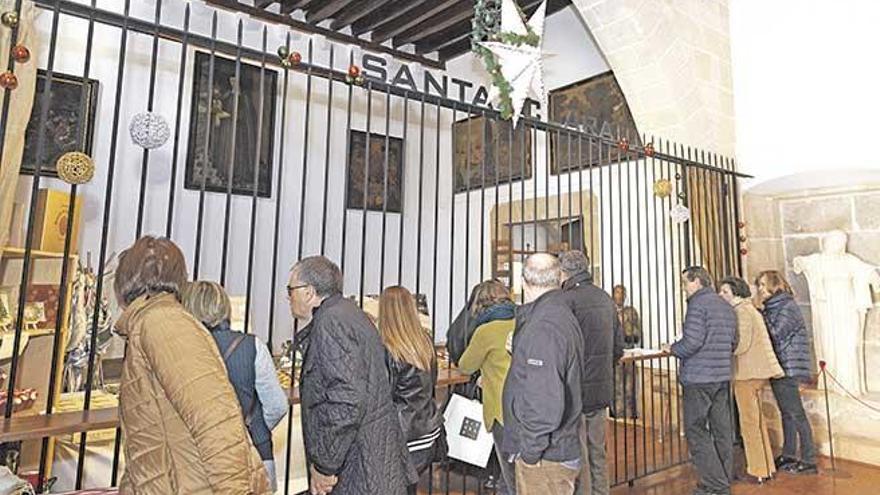 Varias personas aguardan frente a la reja del monasterio para adquirir los dulces que las monjas de clausura venden por Navidad.