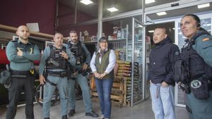 Agentes de la Guardia Civil junto a una vecina rescatada.