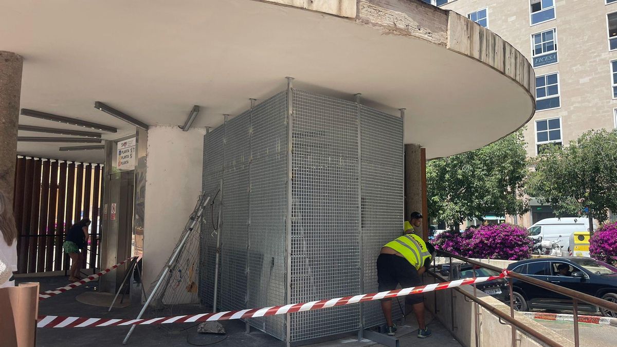 Operarios durante el montaje de la nueva barrera para impedir el paso a los sintecho en la plaza Comtat del Rosselló