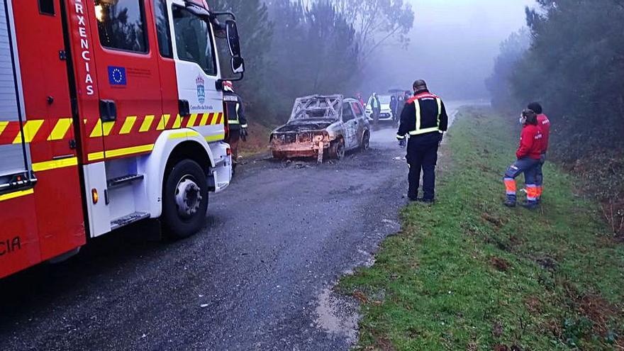 Emerxencias y Protección Civil, ayer, junto al vehículo calcinado.