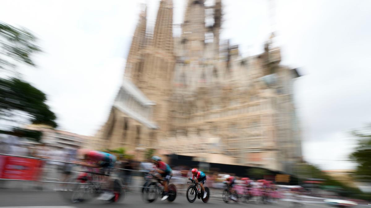 Varios ciclistas, a su paso por la Sagrada Família de Barcelona, durante los entrenamientos previos a la primera etapa de la Vuela Ciclista a España, este sábado