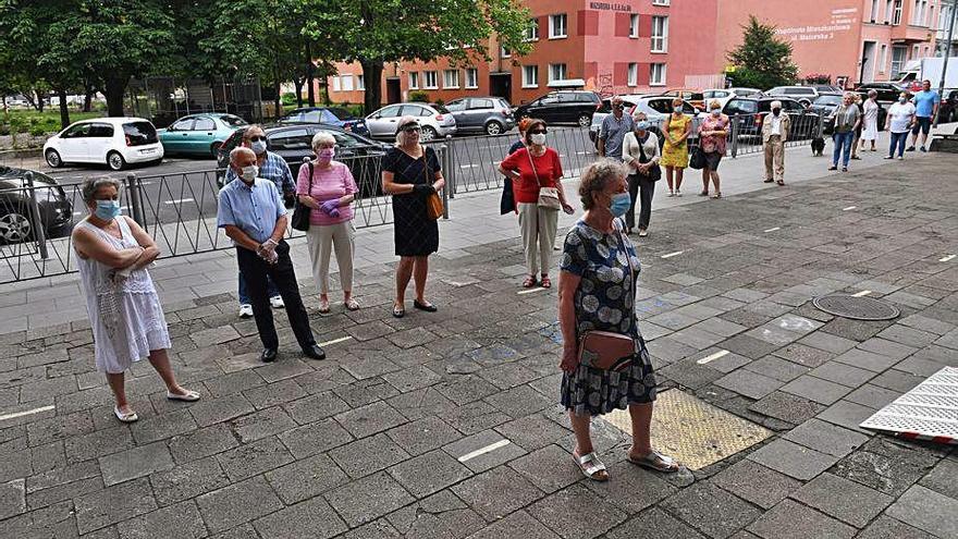 Unas personas acuden a votar ayer en Polonia con mascarillas.