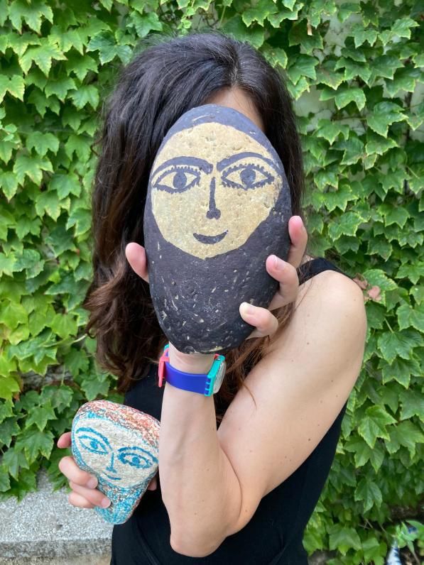 Lucía Buceta con una de las piedras que José Luis Barros pinta con rostro de mujer.