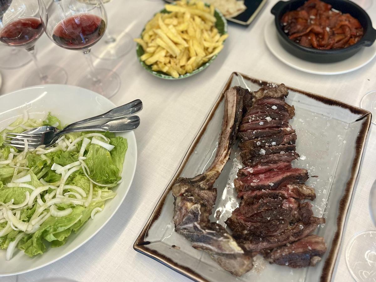 Una chuleta Simmental acompañada de sus guarniciones, en La Taberna de Elia.