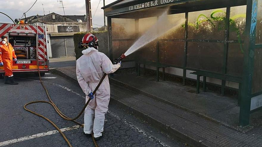 Un operario limpia una marquesina en Bergondo.