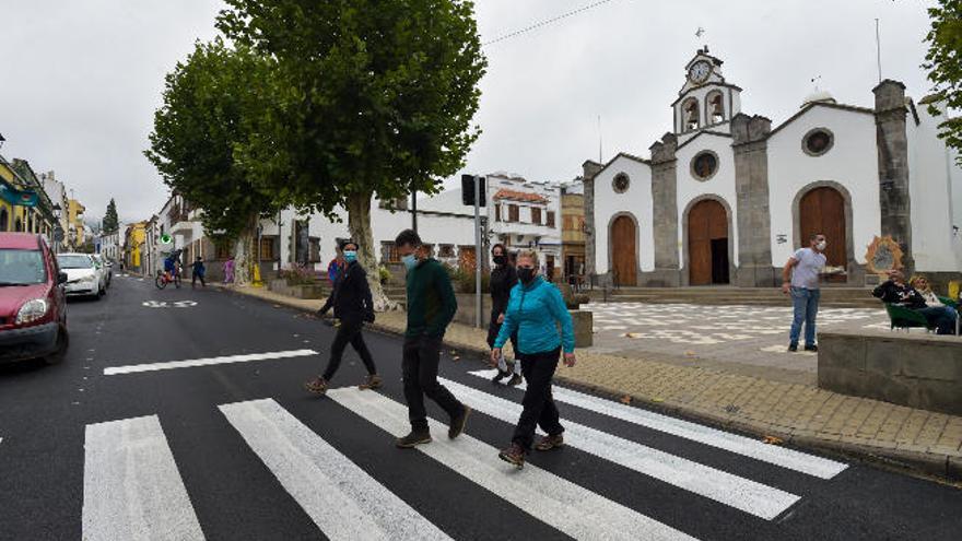 Varias personas cruzan un paso de peatones frente a la iglesia de Valleseco, en Gran Canaria.