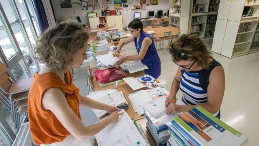 Profesoras de un instituto de Alicante revisan los libros que han dejado los alumnos al acabar el cuso para pedir a Educación la reposición de los que falten.