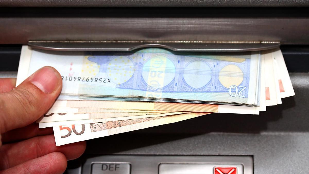 man takes money in EURO banknotes from an ATM man takes money in EURO banknotes from an ATM