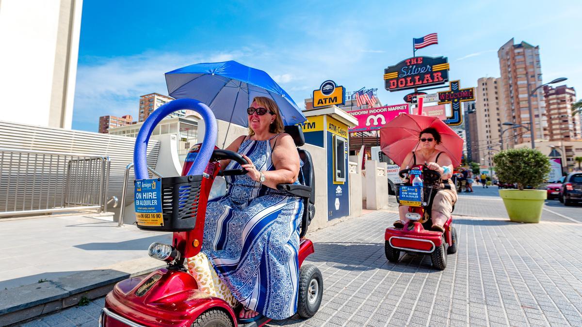 Dos turistas conducen sus sillas autopropulsadas por una acera de la &quot;zona inglesa&quot;, a pesar de estar prohibido en las ordenanzas.