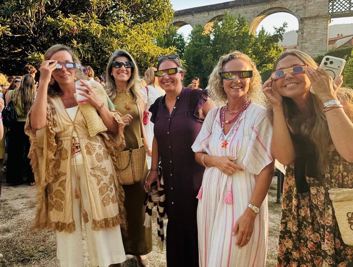 Los asistentes contemplan el eclipse con las gafas homologadas en los jardines.