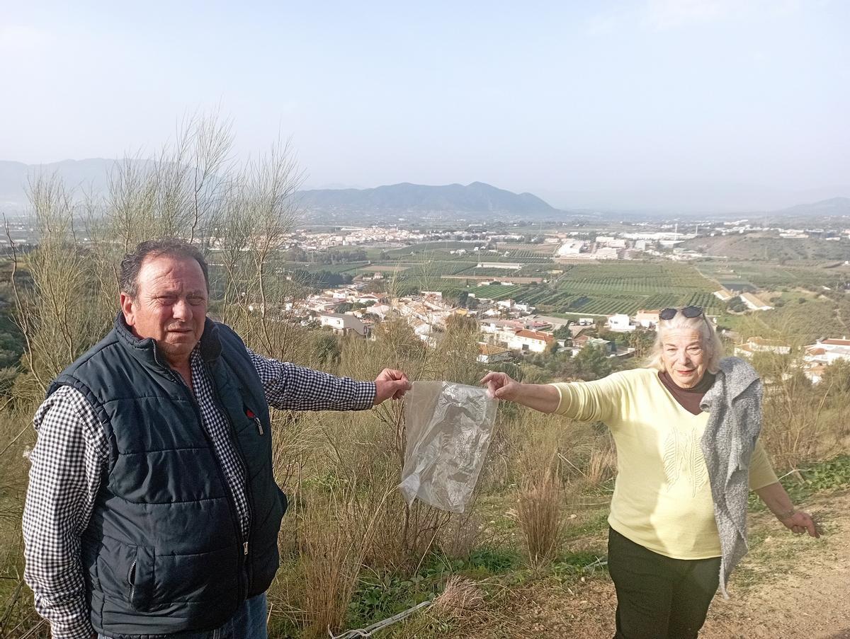José Ángel Moreno y Carmela Fernández sostienen una bolsa de plástico del vertedero.