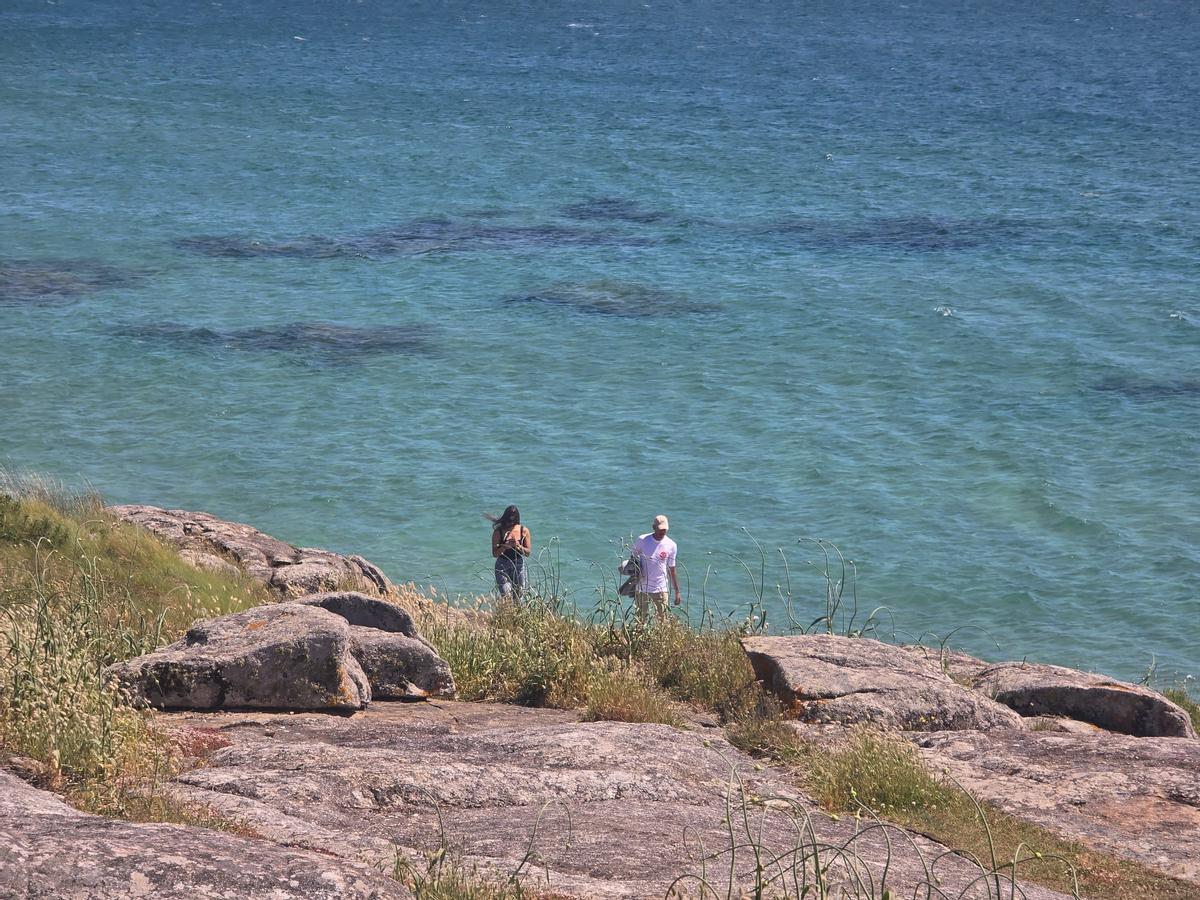 Una pareja paseando por la costa de A Lanzada.