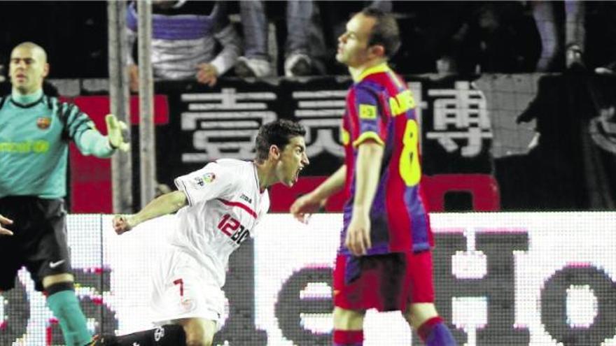 Andrés Iniesta, abatut mentre Jesús Navas celebra el gol que acaba de marcar a Valdés. Era l&#039;empat a 1 d&#039;ahir al Sánchez Pizjuán.