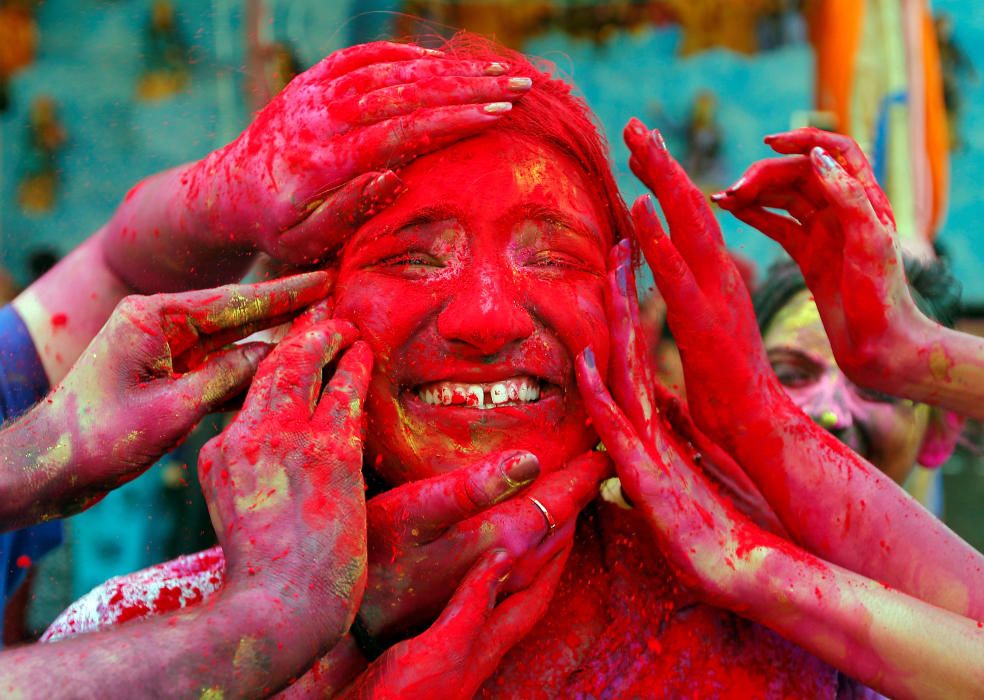 A woman reacts as devotees apply coloured powder ...