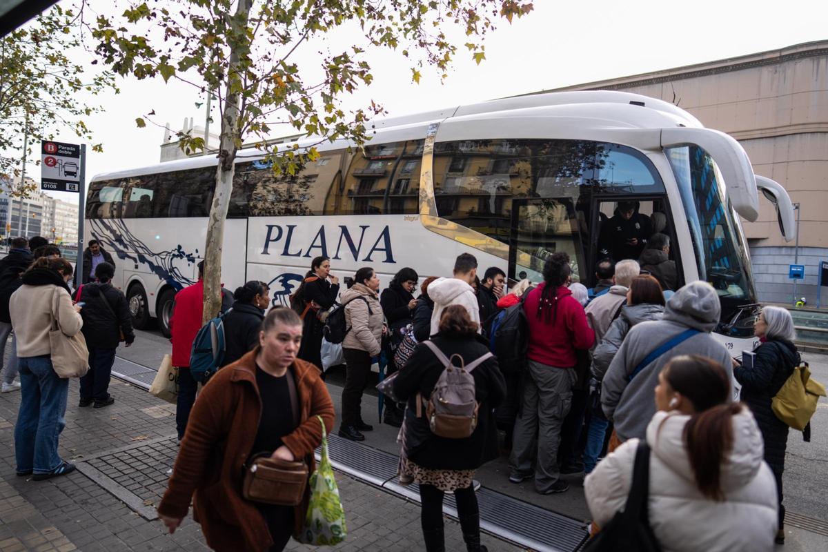 Usuarios hacen cola en la plaza de Espanya para tomar autobuses en dirección a Tarragona