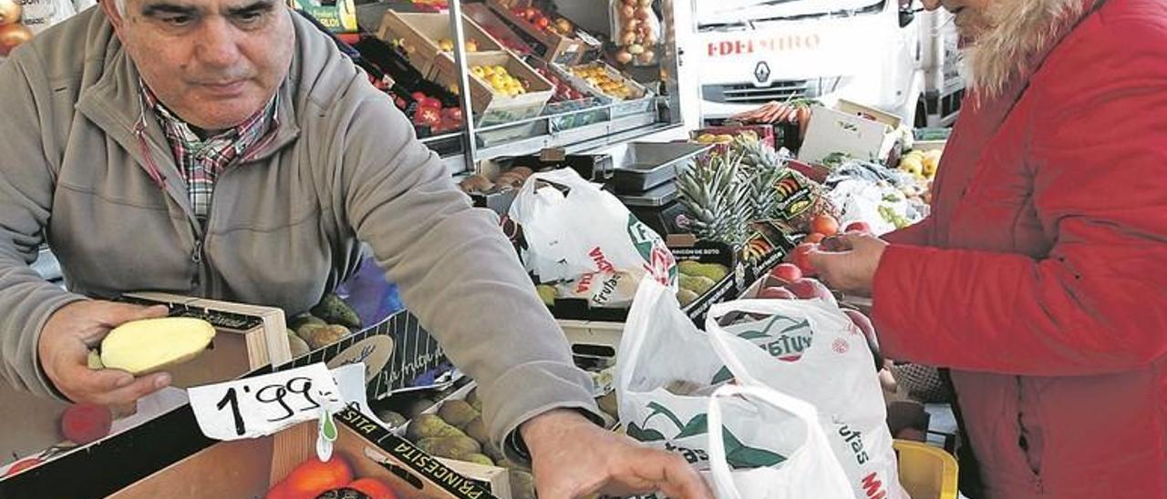 Antonio Díaz vende patatas a Dolores Noceda, ayer, en el mercado de Tapia.