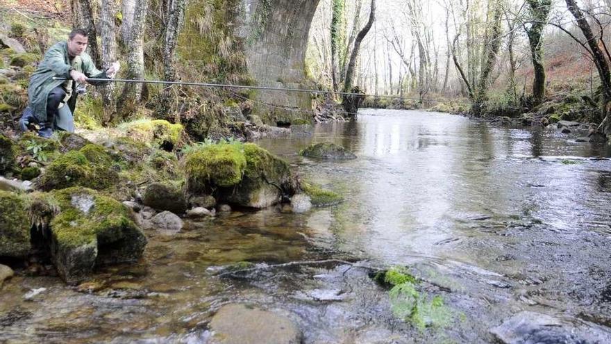 Un pescador, en el río Lérez con escaso caudal.