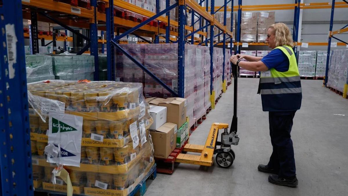 Una trabajadora del Banco de Alimentos Medina Azahara organiza los palés de productos.