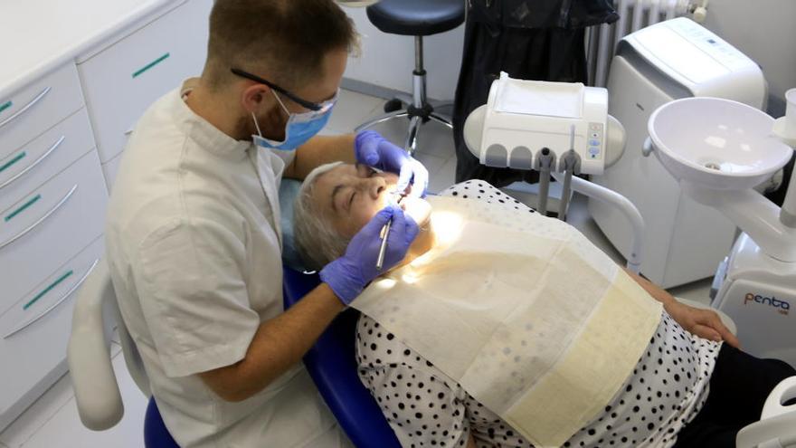 Un odontòleg visitant una pacient, abans de la crisi del coronavirus