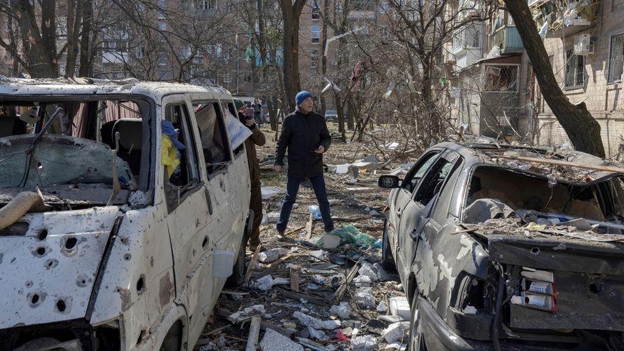 Un hombre camina junto a coches destruidos en Kiev.