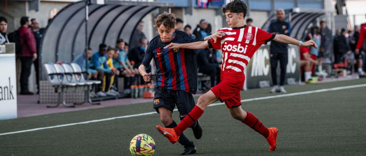 Els alevins U12A del Barça i Girona, al camp de l’Escala. | ALBERT GELI/MIC