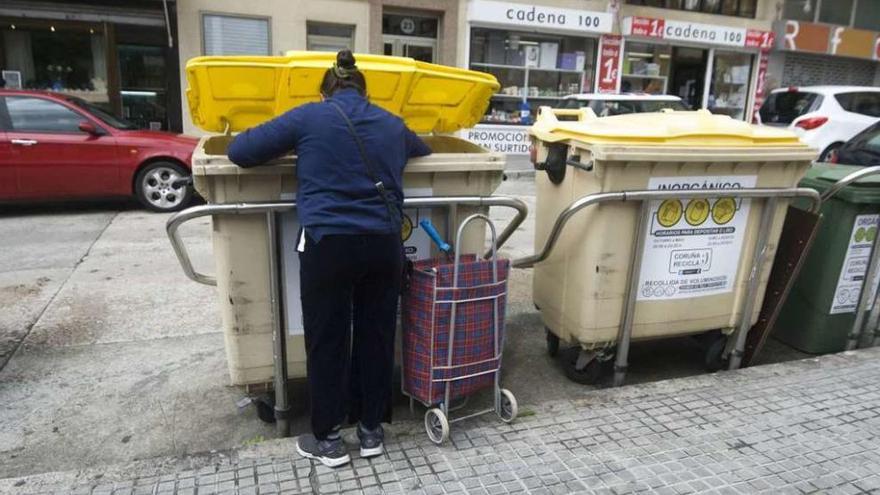 Una mujer busca en unos contenedores de basura de Monte Alto.