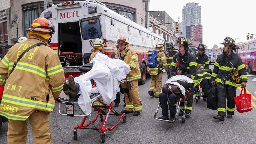 Los bomberos evacuan a los heridos en el accidente del metro de Nueva York.