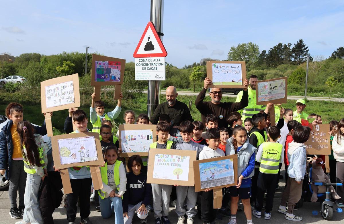 O alcalde, Daniel Pérez, sostén unha pancarta entre os escolares que protagonizan a campaña.