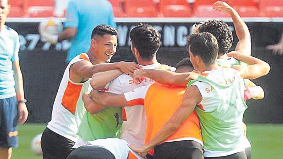 Jugadores del Valencia, abrazados durante un entrenamiento