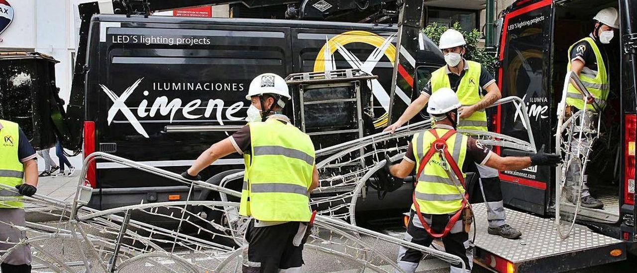 Operarios de Ximénez instalando el alumbrado de Navidad en agosto. // Marta G. Brea