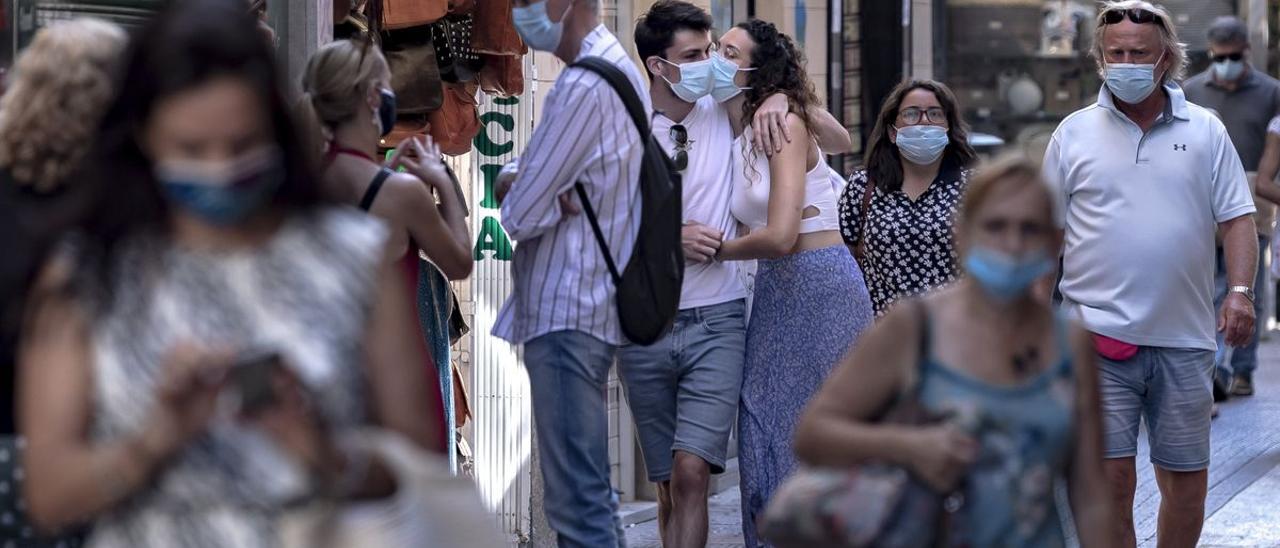 Ciudadanos con mascarilla por la calle en Palma
