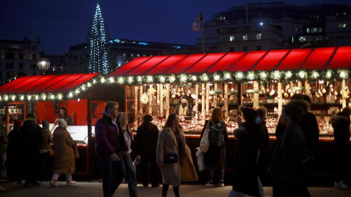 Personas caminando por un mercado navideño en Londres.