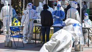 Personal sanitario y voluntarios se realizan test de coronavirus en la localidad china de Jing’, en el distrito de Shanghái, este lunes.