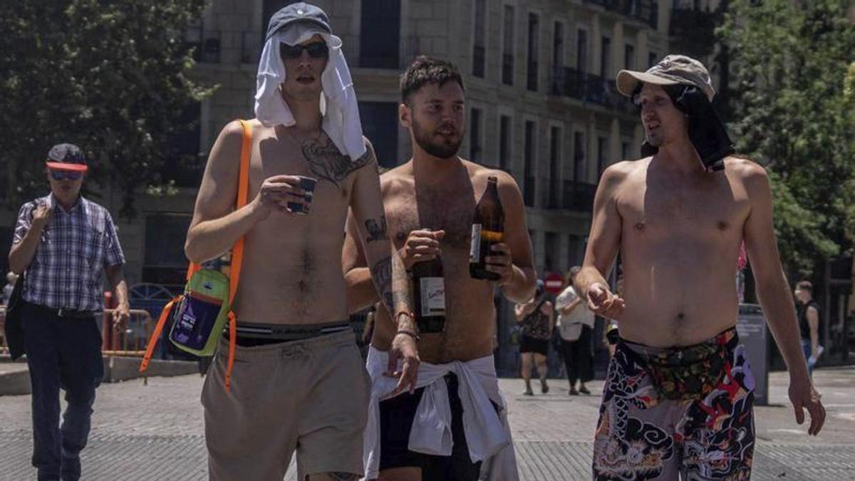 Tres joves es passegen amb el tors descobert a Barcelona, ahir.  | JORDI OTIX