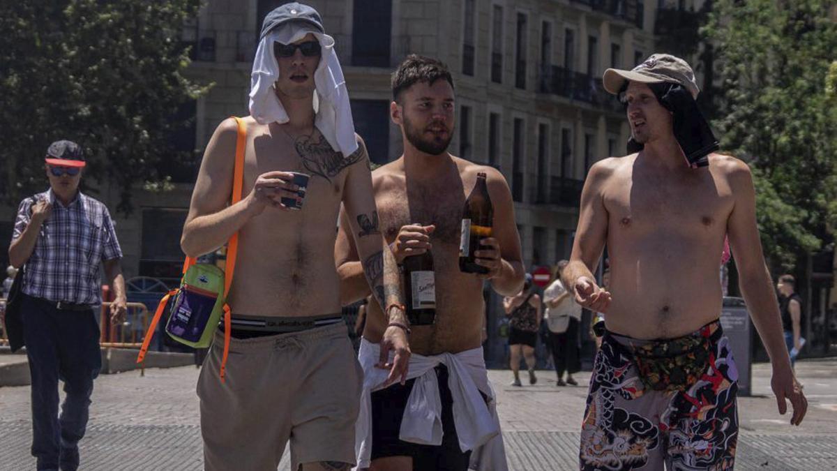 Tres joves es passegen amb el tors descobert a Barcelona, ahir.  | JORDI OTIX